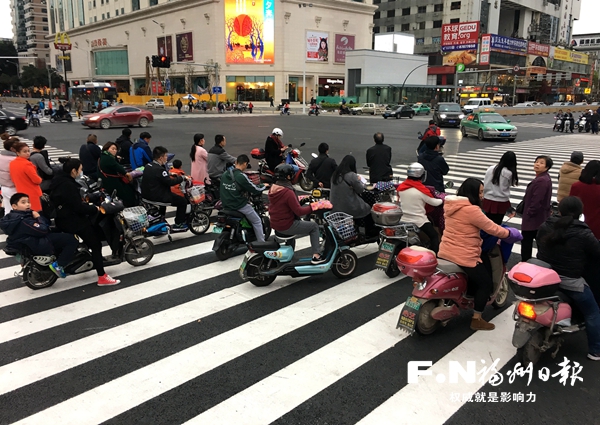 电动车骑手停在斑马线中间等绿灯　存在安全隐患