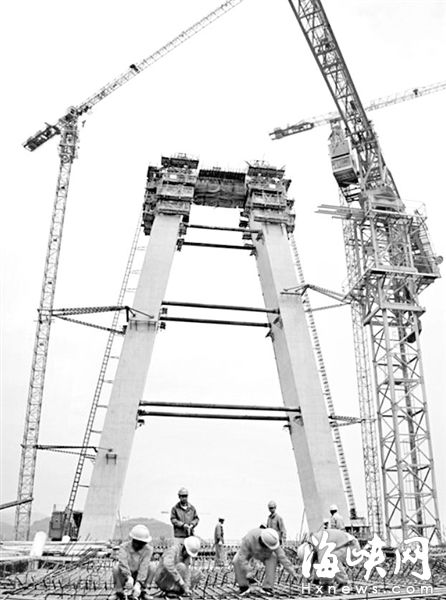 长门特大桥工地，工人正在对大桥边跨上部结构和索塔进行施工