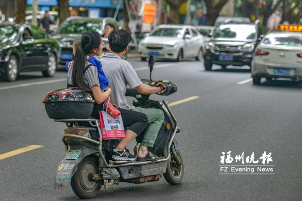 骑车看手机载着大人还“套娃”　电动车违法载人频现